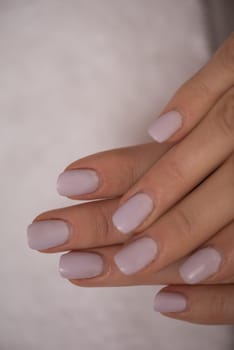 Beautiful fingers with french manicure on the towel. Manicure in a beauty salon.