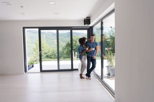 romantic happy young multiethnic couple enjoying morning coffee by the window in their luxury home