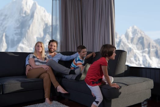 happy couple spending time with kids using tablet computer on sofa at home