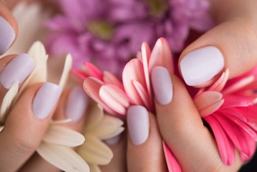 beauty delicate woman hands with manicure holding flower close up