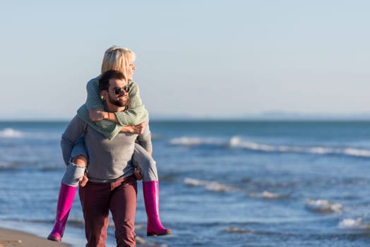 Men Giving Piggy Back Rides to his girlfriend At Sunset By The Sea, autumn time
