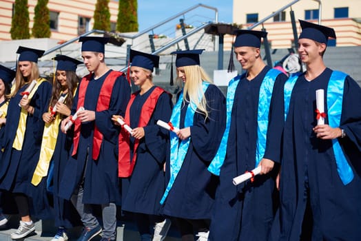 young graduates students group  standing in front of university building on graduation day