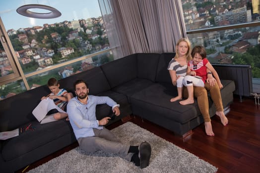 Happy Young Family Playing Together on sofa at home using a tablet and a children's drawing set