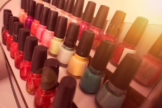 Set of different bottles of nail polish in the shelf in the beauty salon