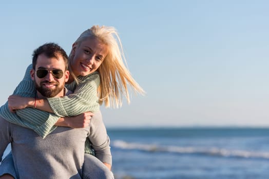 Men Giving Piggy Back Rides to his girlfriend At Sunset By The Sea, autumn time