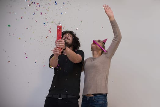 happy young romantic  couple in love  celebrating and blowing confetti decorations at new year and charismas  party