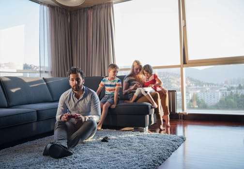 Happy family. Father, mother and children playing a video game Father and son playing video games together on the floor