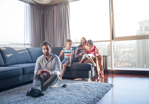 Happy family. Father, mother and children playing a video game Father and son playing video games together on the floor