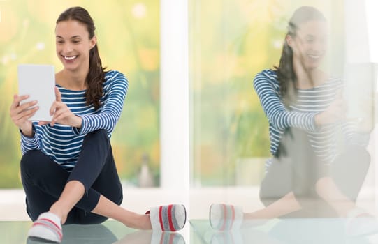 beautiful young women using tablet computer on the floor at home