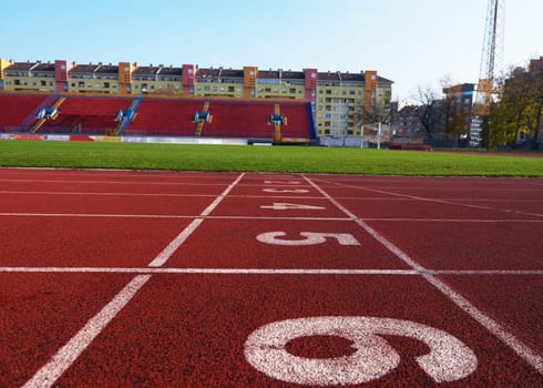 Red athletic track treadmill at the stadium with the numbering.