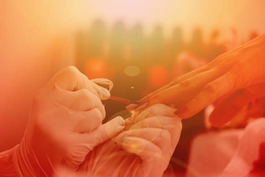 Woman hands receiving a manicure in beauty salon. Nail filing. Close up, selective focus.