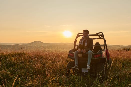 portrait of young happy excited man enjoying beautiful sunny day while driving a off road buggy car on mountain nature
