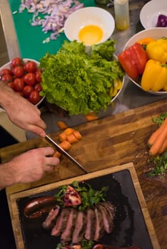 top view of Chef hands in hotel or restaurant kitchen preparing beef steak with vegetable decoration