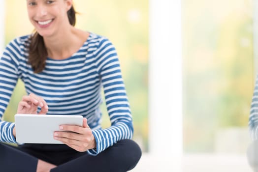 beautiful young women using tablet computer on the floor at home
