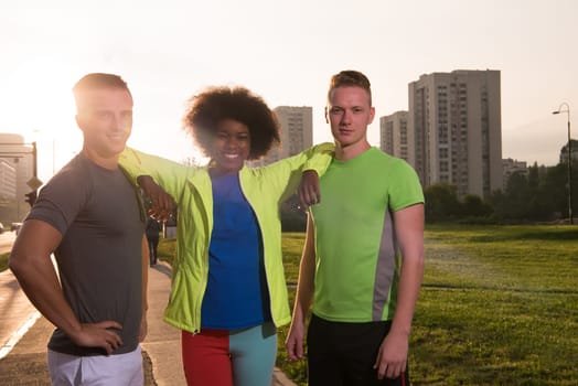 Portrait of multi-ethnic group of young people on the jogging beautiful summer evening as the sun sets over the city
