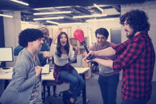 multiethnics startup business team of software developers having fun while boxing at office,excited diverse employees laughing enjoying funny activity at work break, creative friendly workers playing game together