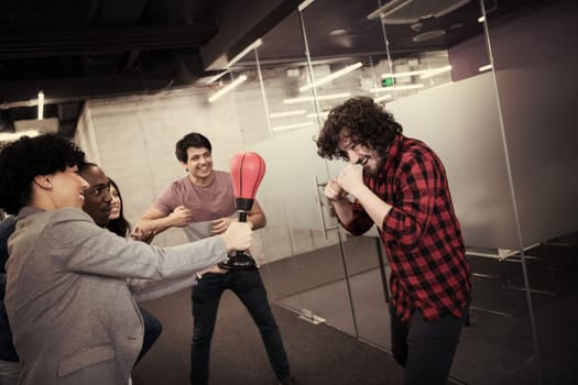 multiethnics startup business team of software developers having fun while boxing at office,excited diverse employees laughing enjoying funny activity at work break, creative friendly workers playing game together