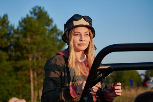 a portrait of a young girl wearing a helmet and enjoying a buggy car ride on a mountain