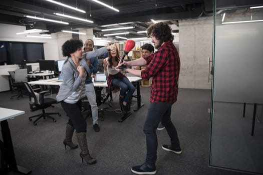 multiethnics startup business team of software developers having fun while boxing at office,excited diverse employees laughing enjoying funny activity at work break, creative friendly workers playing game together