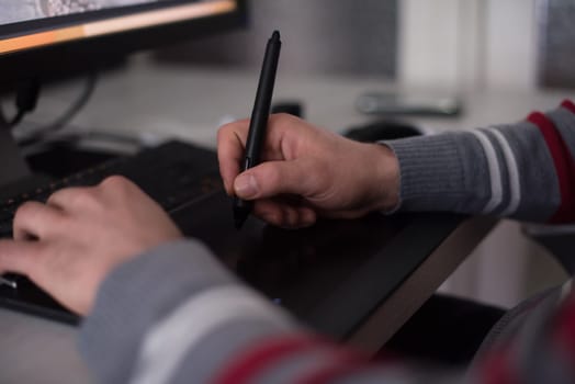 Young graphic designer working on a digital tablet and a computer