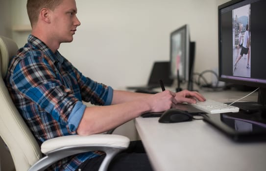 Young graphic designer working on a digital tablet and a computer