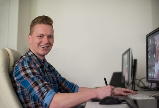Young graphic designer working on a digital tablet and a computer