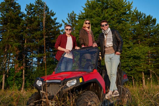 portrait of group young happy people enjoying beautiful sunny day while driving a off road buggy car on mountain nature