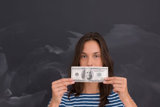 portrait of a young woman holding a banknote in front of chalk drawing board