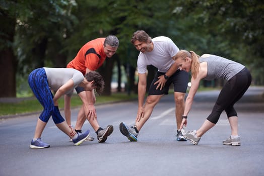 jogging people group stretching in park before training