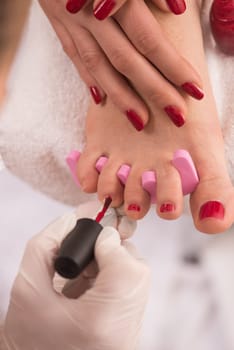 Closeup photo of a female feet and hands at spa salon on pedicure and manicure procedure