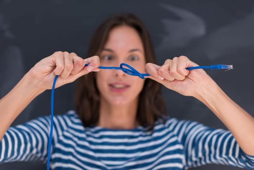 portrait of a young woman holding a internet cable in front of chalk drawing board