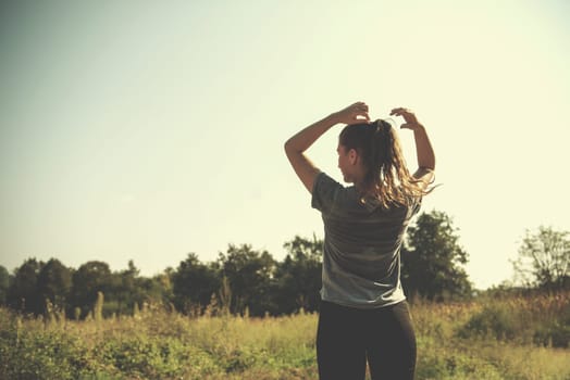 young woman enjoying in a healthy lifestyle while jogging along a country road, exercise and fitness concept