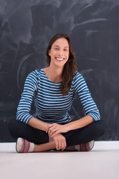 portrait of a young woman sitting in front of chalk drawing board