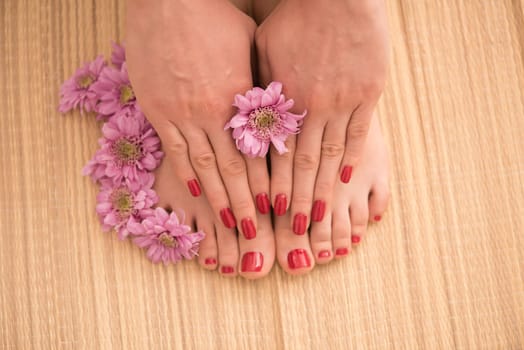 Closeup photo of a female feet and hands at spa salon on pedicure and manicure procedure