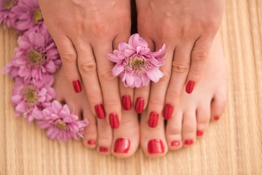 Closeup photo of a female feet and hands at spa salon on pedicure and manicure procedure