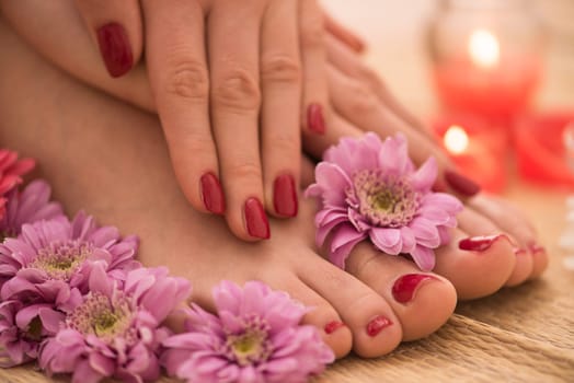 Closeup photo of a female feet and hands at spa salon on pedicure and manicure procedure