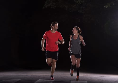 group of healthy people jogging in city park, runners team at night training