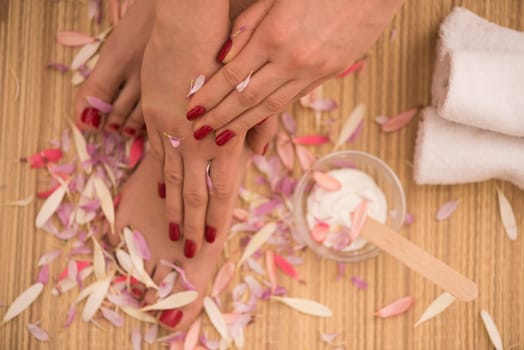 Closeup photo of a female feet and hands at spa salon on pedicure and manicure procedure