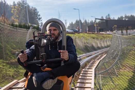 young videographer with gimball video slr at work on alpine coaster