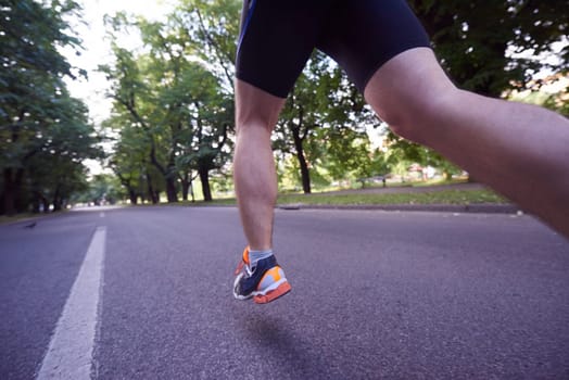 healthy athlete man jogging at morning on empty  roat in the city
