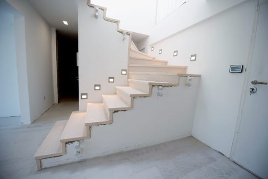 stylish interior with wooden stairs in big modern two level luxury apartment