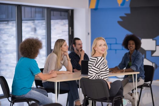 Multiethnic startup business team on meeting in modern bright office interior brainstorming, working on laptop and tablet computer