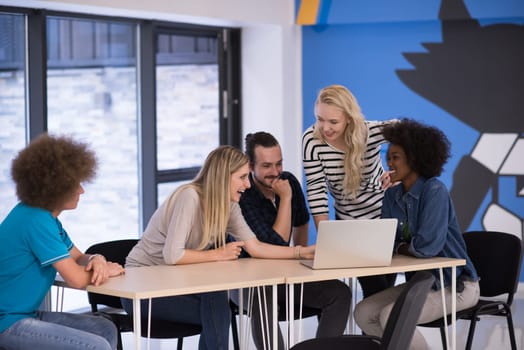 Multiethnic startup business team on meeting in modern bright office interior brainstorming, working on laptop and tablet computer