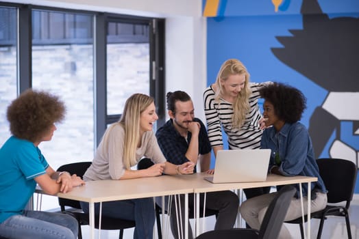 Multiethnic startup business team on meeting in modern bright office interior brainstorming, working on laptop and tablet computer