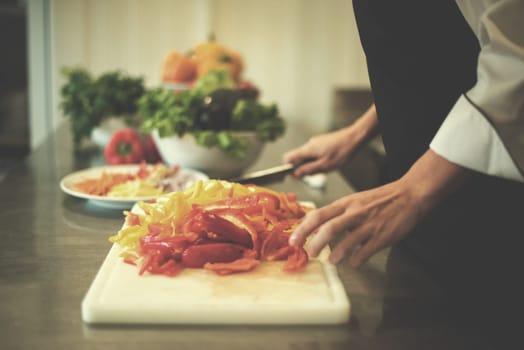 Chef cutting fresh and delicious vegetables for cooking or salad