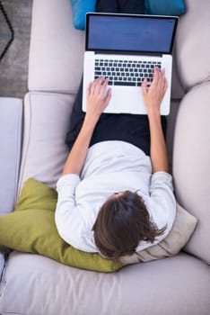 Young woman using her laptop computer in her luxury modern home top view