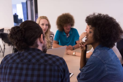 Multiethnic startup business team on meeting in modern bright office interior brainstorming, working on laptop and tablet computer
