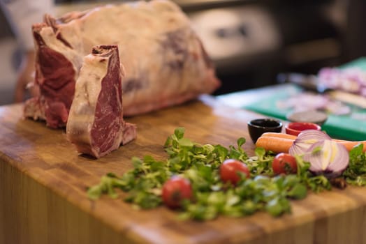 Juicy slice of raw steak  with vegetables on a wooden table