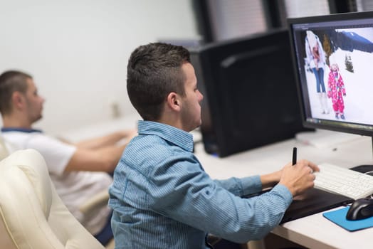 photo editors working with graphic tablet and pen on photographs in retouching studio