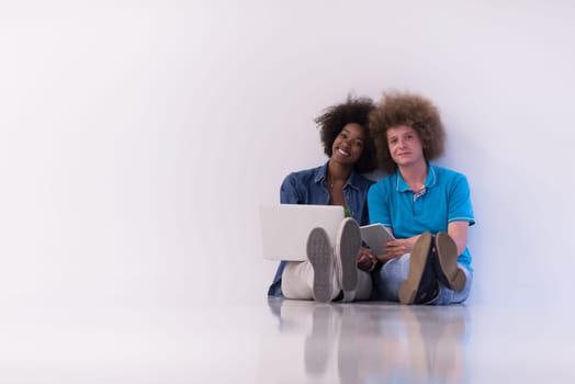 startup business and new mobile technology concept with young multiethnic couple in modern bright office interior working on laptop and tablet computer on new creative project and brainstorming
